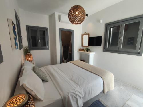 a bedroom with a bed and a pendant light at Krotiri View Paros in Krotiri