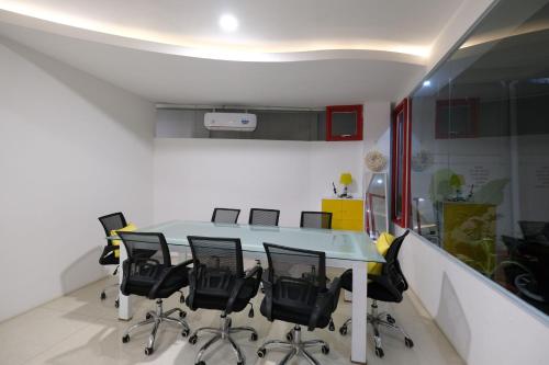a conference room with a table and black chairs at S101 Hotels in Semarang