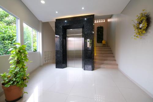 a hallway with a door and a potted plant at S101 Hotels in Semarang