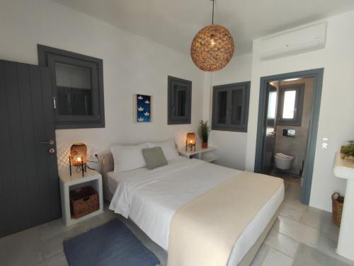 a bedroom with a large white bed with two lamps at Krotiri View Paros in Krotiri