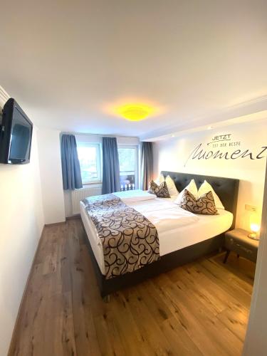 a bedroom with a bed and a television in it at GRUBERS, Hotel Appartments Gastein in Bad Gastein