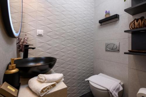 a bathroom with a black sink and a toilet at Enavlion Luxury Domes in Panayia