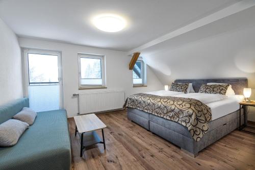 a bedroom with a bed and a couch at GRUBERS, Hotel Appartments Gastein in Bad Gastein