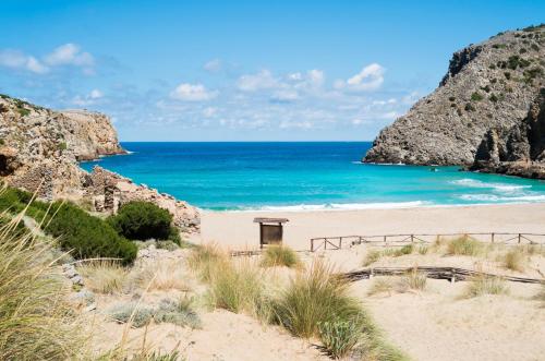 une plage de sable avec l'océan en arrière-plan dans l'établissement LA VIA DEL MARE, à Iglesias
