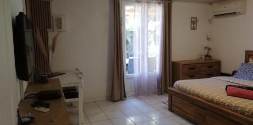 a bedroom with a bed and a table and a television at La CAZ A NOU in Saint-Pierre
