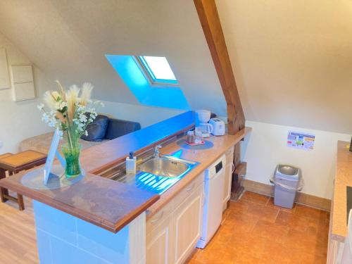 a kitchen with a sink and a vase of flowers at La longère T3 - Au Golf de Bellême - Parking - Wifi - 4 Pers in Bellême