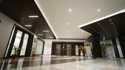 a lobby with flowers in vases in a building at Ramada by Wyndham Aligarh GT Road in Alīgarh