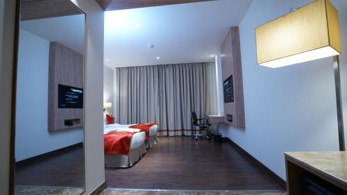 a hotel room with a bed and a desk at Ramada by Wyndham Aligarh GT Road in Alīgarh