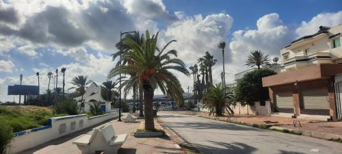 a city street with palm trees and a building at Appartement near the sea in La Goulette