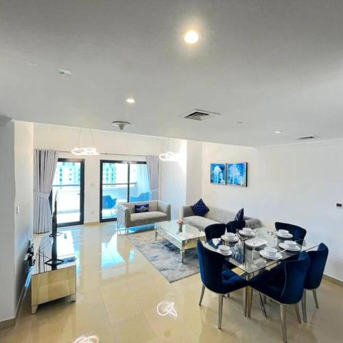 uma sala de estar com uma mesa e cadeiras azuis em Time Place retreat residence-2BR-Dubai Marina-Waterfront living no Dubai