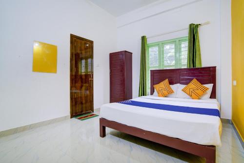 a bedroom with a large bed with orange and blue pillows at OYO Hotel 76900 Dream Palace in Kovalam