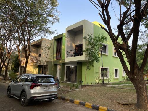 a car parked in front of a green building at Samruddhi S3 homestay garden villa or S1 in Nagpur