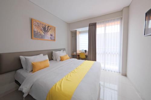 a bedroom with a large bed with yellow pillows at S101 Hotels in Semarang