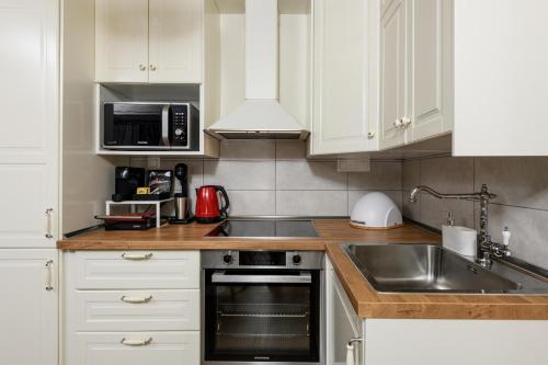 a kitchen with white cabinets and a stainless steel sink at Enavlion Luxury Domes in Panayia