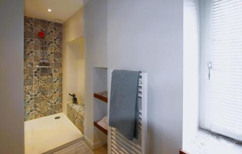 La salle de bains est pourvue d'une douche à l'italienne à côté d'un mur en pierre. dans l'établissement Awesome Home In Colonzelle With Private Swimming Pool, Can Be Inside Or Outside, à Colonzelle