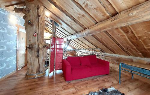 2 Bedroom Awesome Home In Tendon في تيندون: أريكة حمراء في غرفة بها شجرة