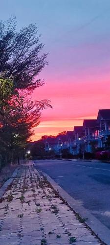 a street with houses and a sunset in the background at Bougainviella - Sealinks Mũi Né - chuỗi biệt thự liền kề in Phan Thiet