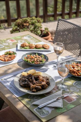 a table with plates of food and glasses of wine at Earino in Kato Asites
