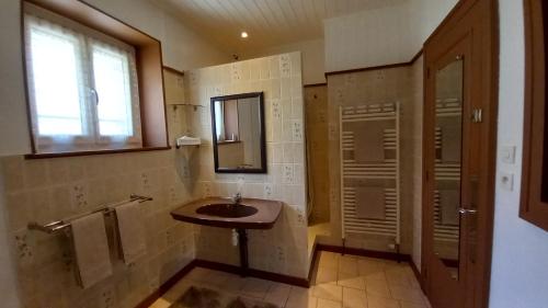 a bathroom with a sink and a mirror and a window at Studio d'hôtes à 10 km de Gérardmer (Le Tholy) in Le Tholy