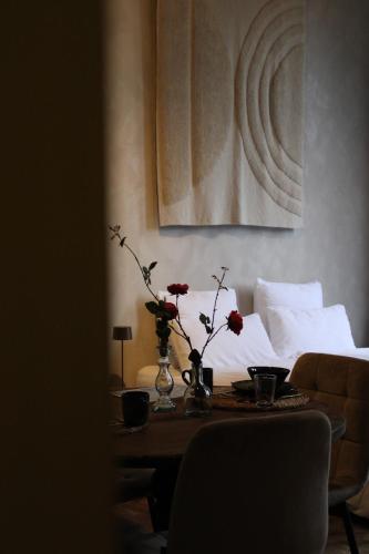 a living room with a table with flowers on it at Logies aan de Dam in Middelburg