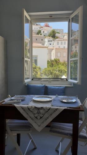 a table with two plates on it in front of a window at Diamond Suite in Hydra