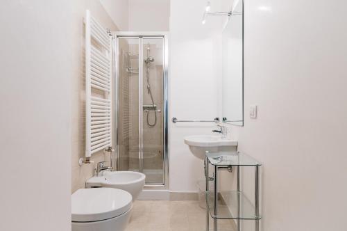 y baño con aseo, lavabo y ducha. en Sartori Mountain Apartment en Pinzolo