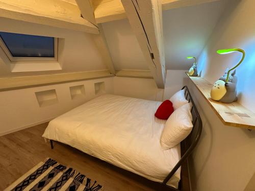 Kleines Zimmer mit einem Bett mit weißer Bettwäsche und einem Fenster. in der Unterkunft Cocon lumineux T3 proche de Lyon, facile d'accès in Saint-Fons