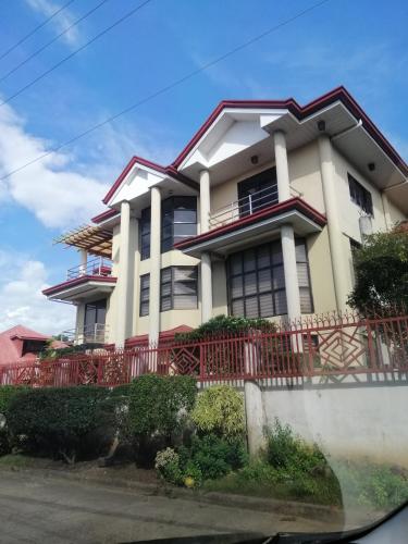 une maison avec une clôture rouge devant elle dans l'établissement JD Homestays CDO, à Cagayán de Oro