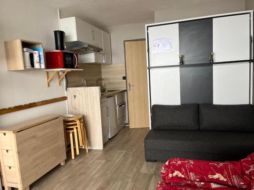 pequeña sala de estar con sofá y cocina en Studio refait à neuf avec balcon Ouest Résidence Le Galaxie en Villard-de-Lans