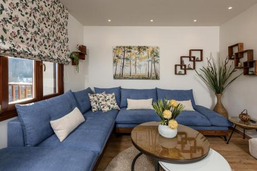 a living room with a blue couch and a table at Enavlion Luxury Domes in Panayia