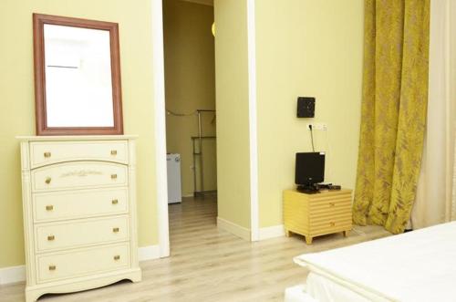a bedroom with a white dresser and a window at Hotel Menshikov in Odesa