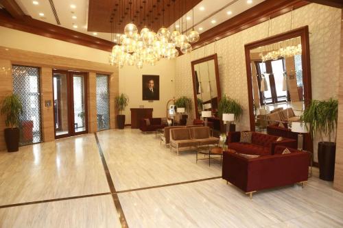 a lobby with couches and chairs and a chandelier at Ramada by Wyndham Multan in Multan
