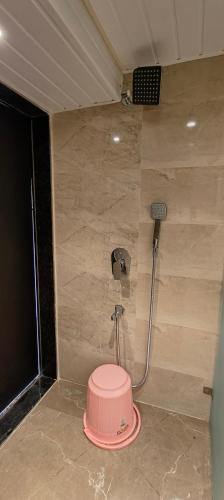 a shower with a pink toilet in a room at Grand Dyad Hotel - Near Kokilaben Hospital Andheri West in Mumbai