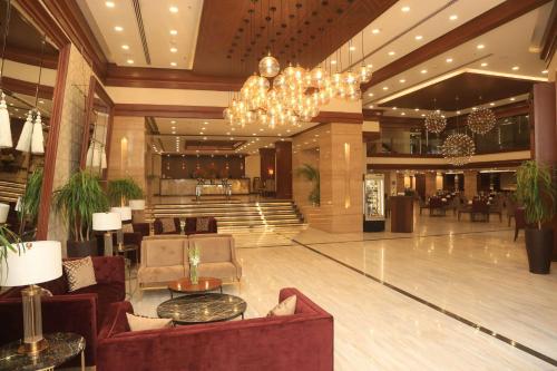 a lobby of a hotel with couches and a chandelier at Ramada by Wyndham Multan in Multan