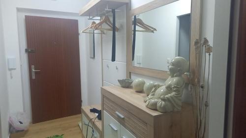 a bathroom with a mirror and a statue on a dresser at Riccis 47m2 bamboo flat in Grosspertholz