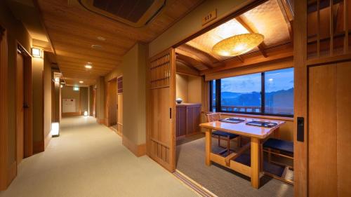 a corridor of a room with a table and a window at Kashintei Shirahama in Senboku