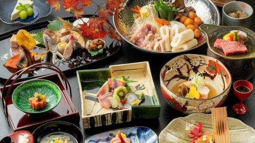 una mesa con muchos tipos diferentes de comida en ella en Kashintei Shirahama, en Senboku