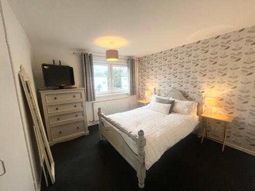 1 dormitorio con 1 cama y TV en la pared en Spacious 2 double bed city home, en Hereford