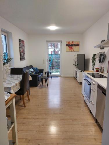 eine Küche und ein Wohnzimmer mit einem Tisch und einem Sofa in der Unterkunft Villa Bianca - Holiday & Business in Elsenfeld