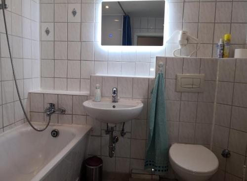 een badkamer met een wastafel, een toilet en een spiegel bij Ferienwohnung Wroblewsky in Klein Ziethen