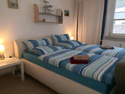 1 cama con sábanas azules y blancas en un dormitorio en Ferienwohnung Wroblewsky, en Klein Ziethen