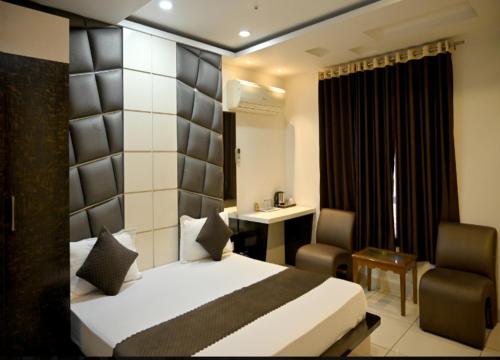 ein Hotelzimmer mit einem Bett und einem Stuhl in der Unterkunft Hotel MY Dream in Aligarh