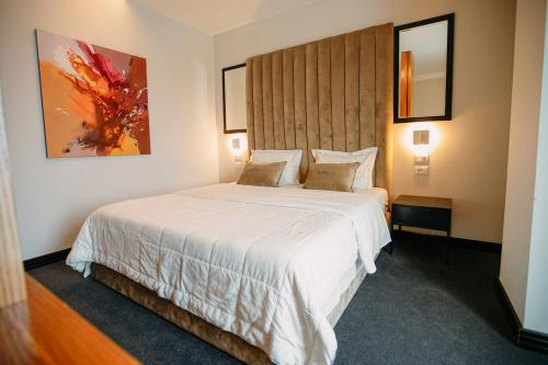 a bedroom with a large white bed in a room at Hotel Delta Premium in Durrës