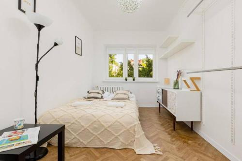 Habitación blanca con cama y escritorio en Mieszkanie Nowolipie Blisko Centrum en Varsovia