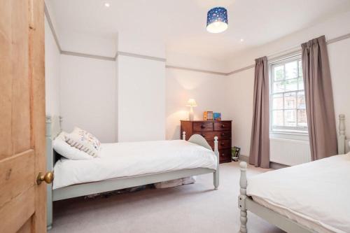 a bedroom with two beds and a window at Perfect Cosy Cottage in Litcham