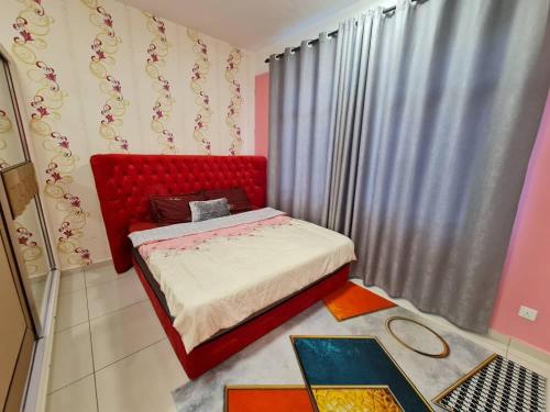 een slaapkamer met een rood bed in een kamer bij Homestay Epoh Meru Raya F3 with Netflix in Ipoh
