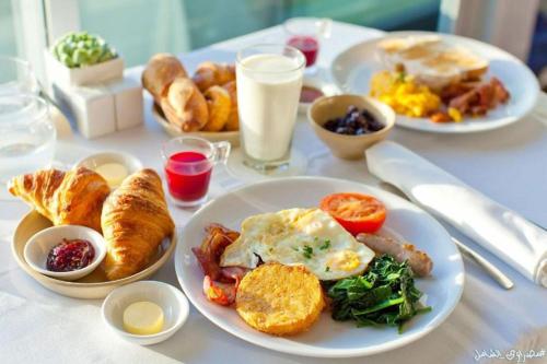 a table with plates of breakfast food on it at Gardenia Apartment Pyramids View in Cairo