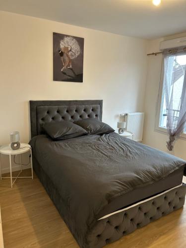 - une chambre avec un grand lit et une couette grise dans l'établissement Appt spacieux et calme prox Disney-CDG-Stade de France, au Blanc-Mesnil
