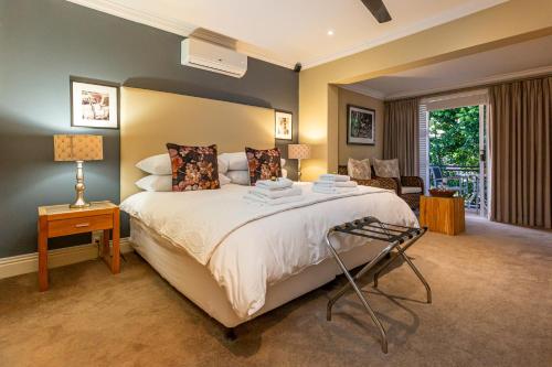 a bedroom with a large bed and a living room at Pictures Guest House Boutique Hotel in Oudtshoorn