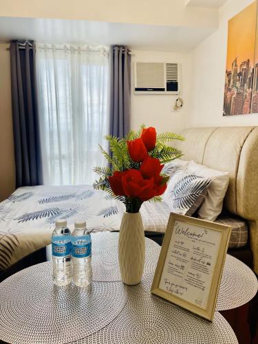 a room with a table with a vase of red roses at City View Studio Unit at Centrio Tower beside Ayala Mall in Cagayan de Oro